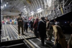 Warga Afghanistan memasuki pesawat angkut AS untuk dievakuasi. (Foto: via AP)