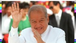 FILE - Cambodian King Norodom Sihanouk waving to bystanders on his way to greeting Indonesian President Suharto in Phnom Penh.