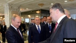 FILE - Russian President Vladimir Putin (L) shakes hands with his Ukrainian counterpart Petro Poroshenko at the start of talks in Minsk, Belarus, Aug. 26, 2014.