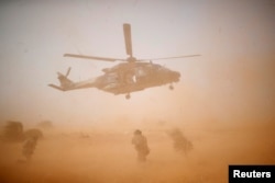 FILE - A NH 90 Caiman military helicopter takes off during the regional anti-insurgent Operation Barkhane in Inaloglog, Mali, Oct. 17, 2017.
