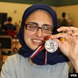 Kulsoom Abdullah menunjukkan medali yang ia menangkan dalam Kejuaraan Tingkat SMA di Georgia tahun lalu.