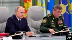Presiden Rusia Vladimir Putin (kiri) dan Panglima militer Rusia, Valery Gerasimov menyaksikan uji coba peluncuran misil hipersonik Avangard hari Rabu (26/12).