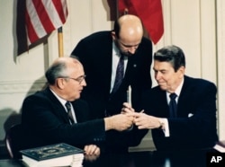FILE - U.S. President Ronald Reagan, right, and Soviet leader Mikhail Gorbachev exchange pens during the Intermediate Range Nuclear Forces Treaty signing ceremony in the White House East Room in Washington, D.C., Dec. 8, 1987.