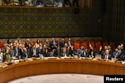 FILE - Ambassadors to the U.N. vote during a United Nations Security Council meeting on North Korea in New York City, Sept. 11, 2017.