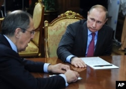 Russian President Vladimir Putin, right, listens to Russian Foreign Minister Sergey Lavrov during their meeting in the Kremlin in Moscow, Russia, March 14, 2016.