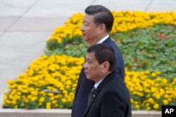 Philippine President Rodrigo Duterte, front, walks with Chinese President Xi Jinping during a welcome ceremony outside the Great Hall of the People in Beijing, China, Oct. 20, 2016.