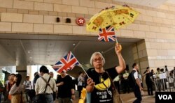 支持者在法庭外高舉黃傘支持佔中九子。（美國之音湯惠芸攝）