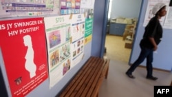FILE - A pregnant woman walks through a community health care clinic in Askham village in the Kalahari, Northern Cape, South Africa, July 2, 2010.