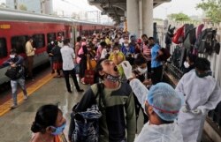 Seorang petugas kesehatan mengambil sampel swab dari seorang pelancong untuk tes COVID-19 di sebuah stasiun kereta api di Mumbai, India, Kamis, 22 Juli 2021. (Foto: AP/Rajanish Kakade)