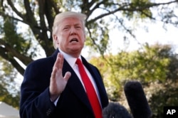 President Donald Trump stops to talk to the media before walking across the South Lawn of the White House in Washington, Oct. 22, 2018, to board Marine One helicopter for a short trip to Andrews Air Force Base, Md., en route to Houston.