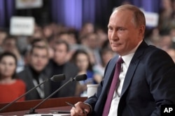 FILE - Russian President Vladimir Putin smiles during his annual news conference in Moscow, Russia, Dec. 14, 2017.