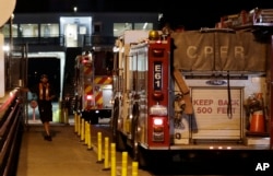 Ferry workers stand by as firetrucks are driven onto a ferry headed to Ketron Island, Aug. 10, 2018, at the ferry terminal in Steilacoom, Washington.