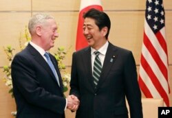U.S. Defense Secretary Jim Mattis, left, and Japanese Prime Minister Shinzo Abe, right, shake hands at the prime minister's office in Tokyo, Feb. 3, 2017.