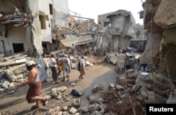 FILE - People gather at the site of a Saudi-led air strike in the Red Sea port city of Hodeidah, Yemen, Sept. 22, 2016.
