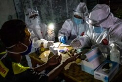 Seorang petugas sedang melakukan tes cepat (rapid tes) Covid-19 terhadap seorang pedagang di sebuah pasar tradisional untuk mencegah transmisi virus corona, di Semarang, Jawa Tengah, 22 Mei 2020.