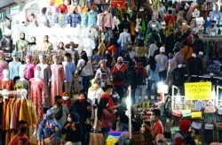 Para pengunjung tetap menggunakan masker saat berbelanja menjelang hari raya Idul Fitri di Pasar Tanah Abang di Jakarta Pusat pada 3 Mei 2021. (Foto: Reuters/Ajeng Dinar Ulfiana)
