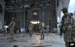 FILE - Pakistani paramilitary soldiers stand alert after a deadly suicide attack at the shrine of famous Sufi Lal Shahbaz Qalandar, in Sehwan, Pakistan, Feb. 16, 2017.