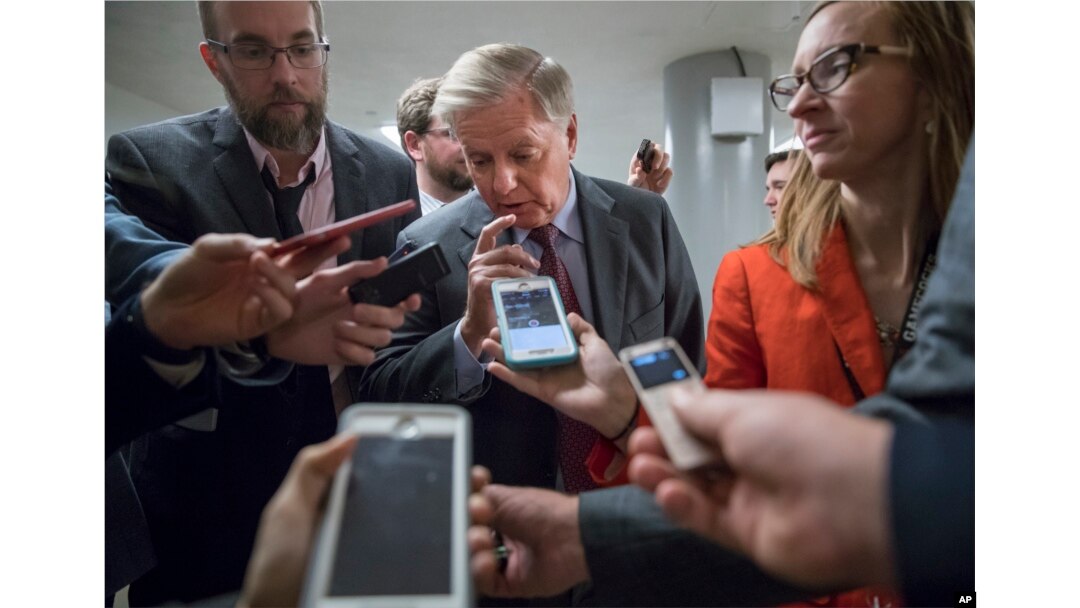With reporters looking for updates, Sen. Lindsey Graham, R-S.C., a member of the Senate Budget Committee, heads to the chamber to vote on amendments as the Republican leadership works to craft their sweeping tax bill, on Capitol Hill in Washington, Nov. 30, 2017.