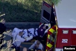 A man who was placed in handcuffs by police is loaded into a paramedic vehicle after a shooting at Marjory Stoneman Douglas High School in Parkland, Fla., Feb. 14, 2018 in this still image from video.