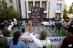 FILE - In this June 20, 2018, photo, protesters demonstrate outside the federal courthouse in Sacramento, Calif., where a judge heard arguments over the U.S. Justice Department's request to block three California laws that extend protections to people in the country illegally. Sacramento is a sanctuary city.