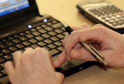 Seorang mahasiswa tengah belajar dengan menggunakan laptopnya. (Foto: AP/Jay LaPrete)