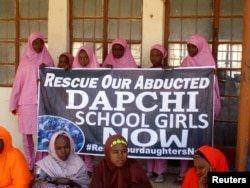 FILE - Schoolgirls wait for the arrival of Nigeria's President Muhammadu Buhari at the government girls' science and technical college in Dapchi, Nigeria, March 14, 2018.