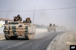 Turkish army tanks and armored personnel carriers move toward the Syrian border, in Karkamis, Turkey, Aug. 25, 2016.