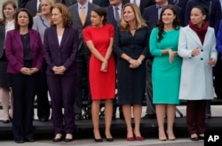FILE - From left, Rep.-elect Angie Craig, D-Minn., Rep.-elect Kim Schrier, D-WA., Rep.-elect Alexandria Ocasio-Cortez, D-NY., Rep.-elect Debbie Mucarsel-Powell, D-Fla., Rep.-elect Abby Finkenauer, D-Iowa, and Rep.-elect Sharice Davids, D-KS., line up as they join other members of the freshman class of Congress for a group photo on Capitol Hill in Washington.