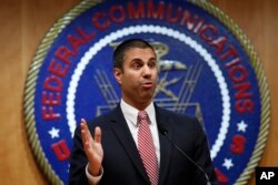 FILE - After a meeting voting to end net neutrality, Federal Communications Commission (FCC) Chairman Ajit Pai answers a question from a reporter, Dec. 14, 2017, in Washington.