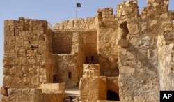Foto yang dirilis 22 Mei 2015 memperlihatkan kelompok bendera ISIS berkibar di atas istana Palmyra, Suriah.
