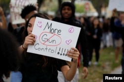Siswa SMU South Plantation membawa poster dan meneriakkan slogan berpawai di jalan untuk mendukung pengendalian penggunaan senjata api setelah penembakan di SMU Marjory Stoneman Douglas, di Plantation, Florida, 21 Februari 2018.