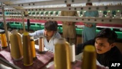 Para pekerja mengawasi mesin bordir untuk gaun-gaun pengantin di sebuah pabrik di luar Kota Islamabad, Pakistan, 2 September 2020. (Foto: Farooq Naeem/AFP)