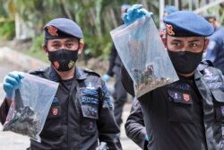 Polisi menunjukkan tas plastik berisi barang bukti yang dikumpulkan dari lokasi ledakan di Gereja Katedral, Makassar, Senin (29/3).