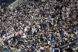 Penggemar bisbol yang telah divaksinasi penuh atau dinyatakan negatif virus dalam 48 jam terakhir atau di bawah 18 tahun, bersorak untuk tim mereka selama pertandingan bisbol wildcard pascamusim KBO antara Kiwoom Heroes dan Doosan Bears di Seoul, Korea Selatan, Senin, 1 November 2021.