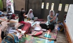 Inggit Andini (kanan) mengajar anak-anak yang tidak punya akses internet di rumahnya, di Tangerang, 10 Agustus 2020.