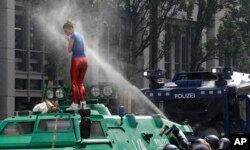 Seorang perempuan terkena semprotan merica polisi saat dia menaiki mobil baja milik polisi pada hari pertama pelaksanaan KTT G-20 di Hamburg, utara Jerman, 7 Juli 2017.