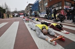 South Korean Buddhist monks and Myanmar nationals living in South Korea march and bow during a protest against Myanmar's military coup in front of the Myanmar embassy in Seoul.