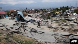 Seorang lelaki berjalan di Balaroa, salah satu daerah terdampak gempa di Palu.