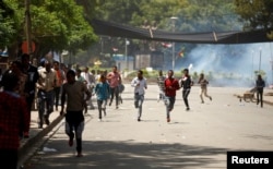 FILE - Protesters run from tear gas being fired by police during Irreecha, the thanks giving festival of the Oromo people in Bishoftu town of Oromia region, Ethiopia, Oct. 2, 2016