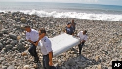 法国警察在留尼汪岛海滩搬运飞机残片