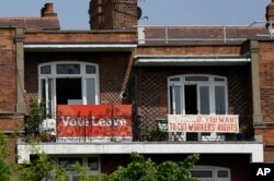 FILE - Banners of opposing views on Britain's so-called Brexit referendum on EU membership are displayed on the balconies of two neighboring apartments in the Gospel Oak area of north London, May 27, 2016. British voters will decide on June 23 on whether