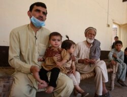 Tariq Nawaz menggendong bayinya, Tuba, yang menderita Polio di Suleiman Khel, Pakistan, 6 Mei 2021. (Foto: AP Photo/Muhammad Sajjad)