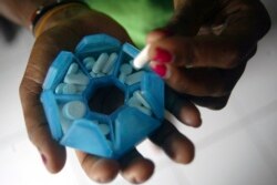 Seorang perempuan yang terinfeksi HIV menyiapkan obat-obatannya di rumah penampungan di Jayapura, Provinsi Papua, 27 November 2008. (Foto: Reuters)