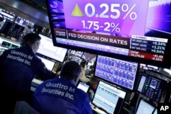 A television screen on the floor of the New York Stock Exchange shows the rate decision of the Federal Reserve, June 13, 2018.