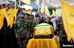 Brothers of top Hezbollah commander Mustafa Badreddine, who was killed in an attack in Syria, mourn over his coffin during his funeral in Beirut's southern suburbs, Lebanon, May 13, 2016