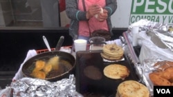 Seorang pedagang kaki lima di Los Angeles, California menyajikan "pupusas" dan makanan tradisional Amerika Latin lainnya. (Foto: A. Martinez/VOA)