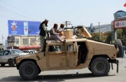 Pejuang Taliban berjaga di depan Bandara Internasional Hamid Karzai, di Kabul, Afghanistan, Senin, 16 Agustus 2021. (AP)