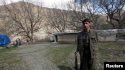FILE - A Kurdistan Workers' Party (PKK) fighter stands guard at the Qandil mountains near the Iraq-Turkish border in Sulaimaniya, 330 km (205 miles) northeast of Baghdad, March 24, 2013.