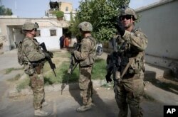 FILE - U.S. military forces stand guard during a visit by Kabul's officials in the governor's compound in Kandahar, Afghanistan, Aug. 4, 2016.