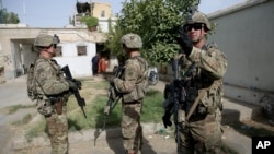 U.S. military forces stand guard during a visit by Kabul's officials in the governor's compound in Kandahar, Afghanistan, Aug. 4, 2016.